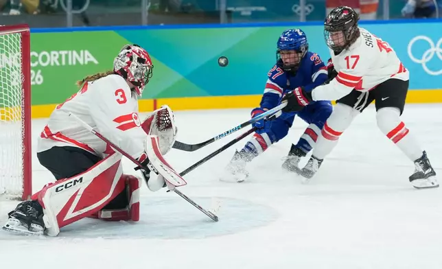 United States' Taylor Heise (27) and Canada's Ella Shelton (17) challenge for the puck during a women's ice hockey gold medal game between the United States and Canada at the 2026 Winter Olympics, in Milan, Italy, Thursday, Feb. 19, 2026. (AP Photo/Petr David Josek)