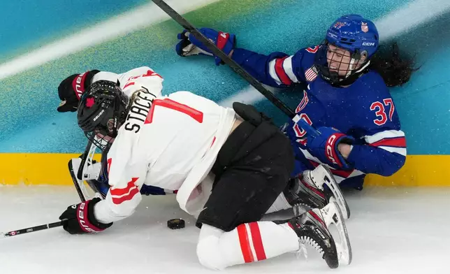 Canada's Laura Stacey (7) and United States' Abbey Murphy (37) battle for the puck during the second period of the women's ice hockey gold medal game at the 2026 Winter Olympics, in Milan, Italy, Thursday, Feb. 19, 2026. (AP Photo/Carolyn Kaster)