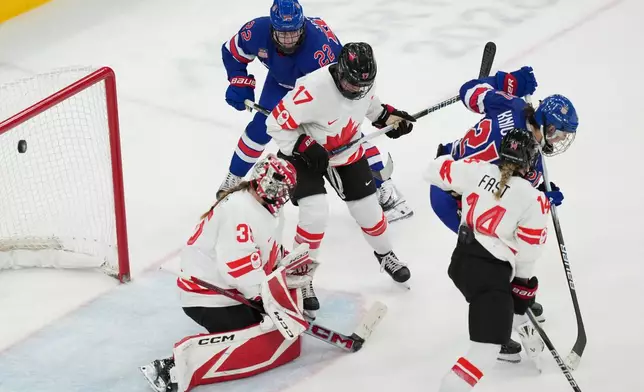 United States' Hilary Knight (21) deflects the puck past Canada goalkeeper Ann-Renee Desbiens (35) for a goal during the third period of the women's ice hockey gold medal game at the 2026 Winter Olympics, in Milan, Italy, Thursday, Feb. 19, 2026. (AP Photo/Carolyn Kaster)
