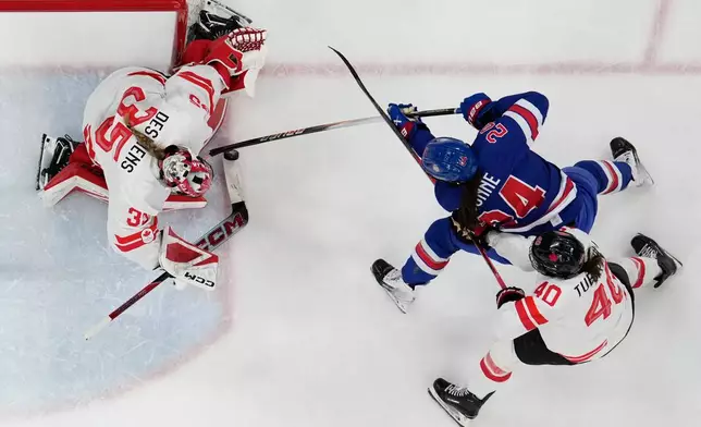 United States' Joy Dunne (24) challenges with Canada's Blayre Turnbull (40) during a women's ice hockey gold medal game between the United States and Canada at the 2026 Winter Olympics, in Milan, Italy, Thursday, Feb. 19, 2026. (AP Photo/Petr David Josek)