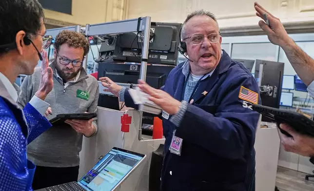 Phil Fracassini, center, works with fellow options traders on the floor of the New York Stock Exchange, Tuesday, Feb. 3, 2026. (AP Photo/Richard Drew)