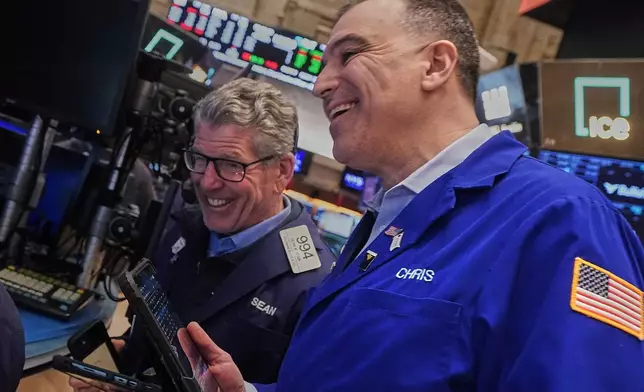 Traders Sean Spain, left, and Chris Lagana work on the floor of the New York Stock Exchange, Tuesday, Feb. 3, 2026. (AP Photo/Richard Drew)