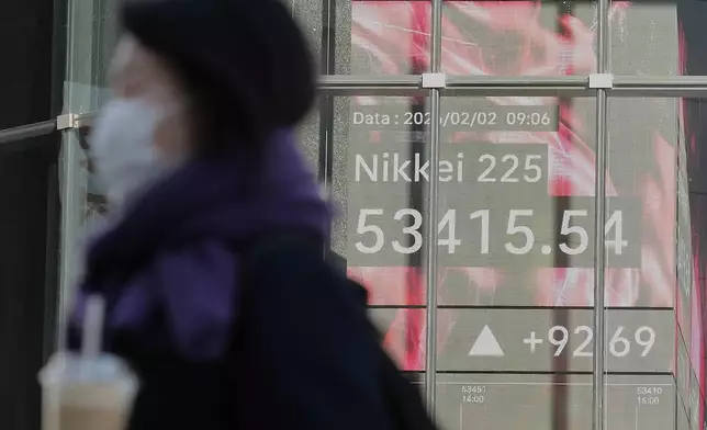 A person walks in front of an electronic stock board showing Japan's Nikkei index at a securities firm Monday, Feb. 2, 2026, in Tokyo. (AP Photo/Eugene Hoshiko)