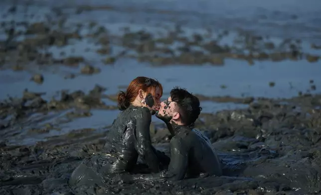 Revelers share a kiss during the Mud Block carnival party in Paraty, Brazil, Saturday, Feb. 14, 2026. (AP Photo/Andre Penner)