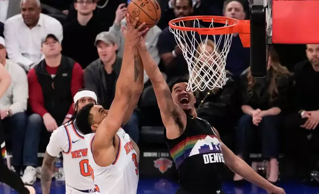 Denver Nuggets forward Spencer Jones (21) fights for control of the ball with New York Knicks center Karl-Anthony Towns (32) during the first half of an NBA basketball game, Wednesday, Feb. 4, 2026, in New York. (AP Photo/Yuki Iwamura)