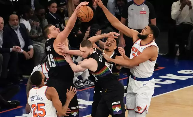 Denver Nuggets center Nikola Jokic (15) fights for control of the ball with New York Knicks center Karl-Anthony Towns (32) during the first half of an NBA basketball game, Wednesday, Feb. 4, 2026, in New York. (AP Photo/Yuki Iwamura)