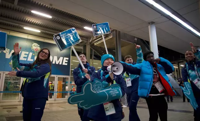 2026 Winter Olympics volunteers gesture at the venue that hosts the women’s ice hockey, in Milan, Italy, Monday, Feb. 9, 2026. (AP Photo/Vasilisa Stepanenko)