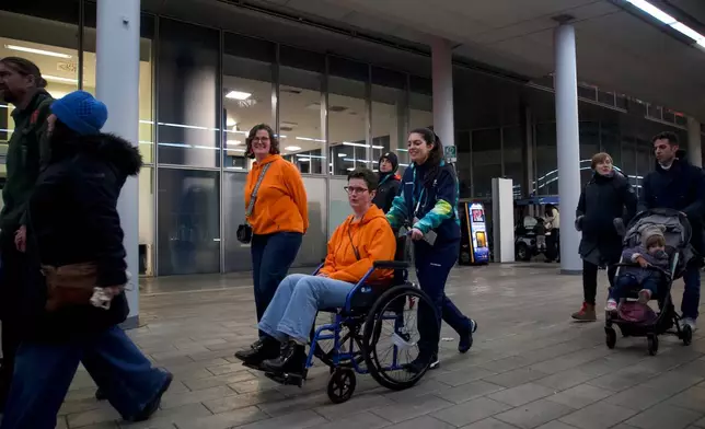 A 2026 Winter Olympics volunteer pushes a spectator in a wheelchair, at the venue that hosts the women’s ice hockey, in Milan, Italy, Monday, Feb. 9, 2026. (AP Photo/Vasilisa Stepanenko)