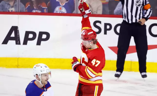 Calgary Flames' Connor Zary celebrates a goal as Edmonton Oilers' Zach Hyman skates past during the second period of an NHL hockey game in Calgary, Wednesday, Feb. 4, 2026. (Larry MacDougal/The Canadian Press via AP)