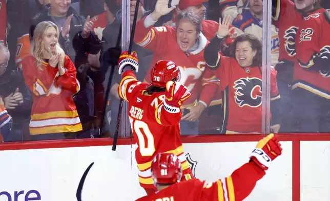 Calgary Flames' Ryan Lomberg celebrates his goal against the Edmonton Oilers with fans during third period NHL hockey action in Calgary, Alberta, Wednesday, Feb. 4, 2026. (Larry MacDougal/The Canadian Press via AP)