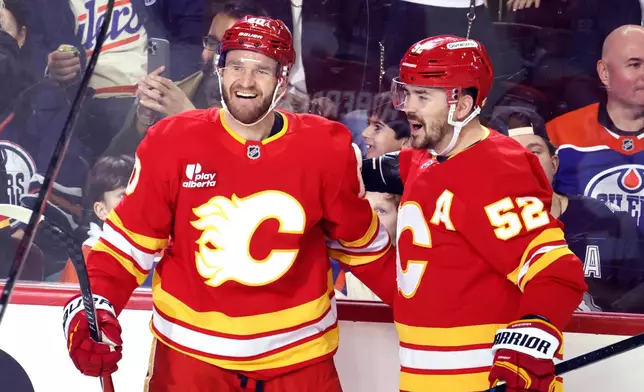 Calgary Flames' Jonathan Huberdeau, left, celebrates a goal with MacKenzie Weegar against the Edmonton Oilers during first period NHL hockey action in Calgary, Alberta, Wednesday, Feb. 4, 2026. (Larry MacDougal/The Canadian Press via AP)