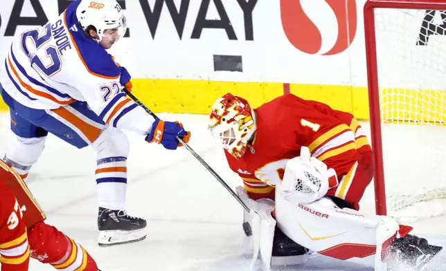 Edmonton Oilers' Matt Savoie, left, is stopped by Calgary Flames goalie Devin Cooley during third period NHL hockey action in Calgary, Alberta, Wednesday, Feb. 4, 2026. (Larry MacDougal/The Canadian Press via AP)