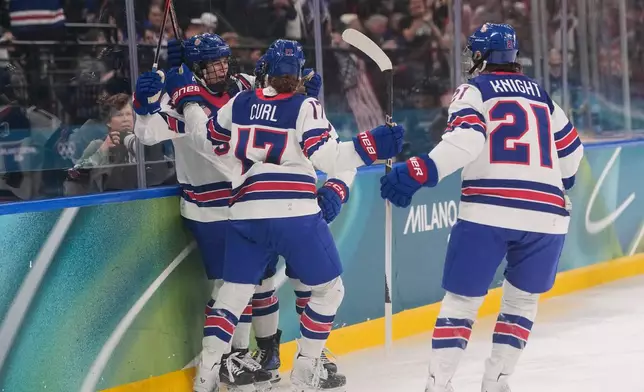 United States' Caroline Harvey celebrates with teammates after scoring her side's first goal during a preliminary round match of women's ice hockey between USA and Canada at the 2026 Winter Olympics, in Milan, Italy, Tuesday, Feb. 10, 2026. (AP Photo/Petr David Josek)