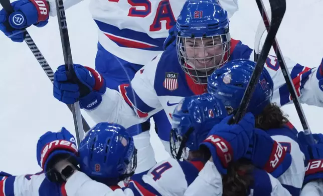 United States' Caroline Harvey celebrates with teammates after scoring her side's first goal during a preliminary round match of women's ice hockey between USA and Canada at the 2026 Winter Olympics, in Milan, Italy, Tuesday, Feb. 10, 2026. (AP Photo/Antonio Calanni)