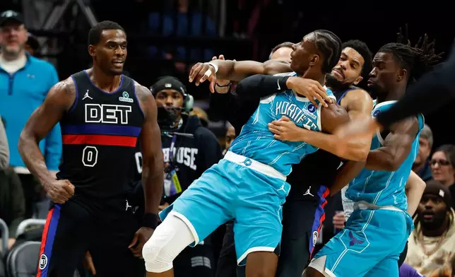 Charlotte Hornets forward Moussa Diabate, second from left, is held back as he goes and Detroit Pistons center Jalen Duren (0) fight during the second half of an NBA basketball game in Charlotte, N.C., Monday, Feb. 9, 2026. (AP Photo/Nell Redmond)