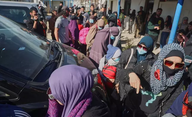 Family members of suspected Islamic State militants who are Australian nationals walk toward a van bound for the airport in Damascus during the first repatriation operation of the year at Roj Camp in eastern Syria, Monday, Feb. 16, 2026. Thirty-four Australian citizens from 11 families departed the camp. (AP Photo/Baderkhan Ahmad)