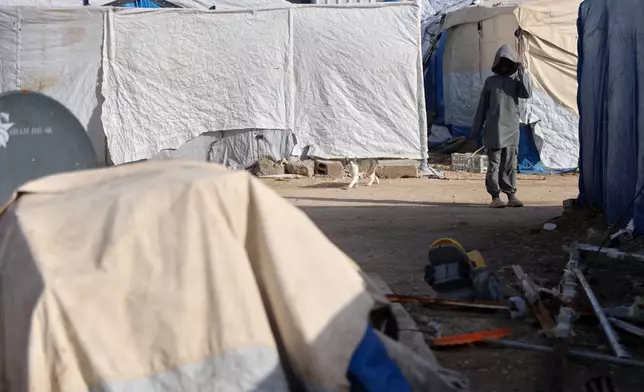 An unidentified boy stands in a section of the camp housing Australian family members of suspected Islamic State militants who were returned to due to unspecified procedural issues following an attempted repatriation by Syrian authorities, in the Roj Camp in eastern Syria, Monday, Feb. 16, 2026. (AP Photo/Baderkhan Ahmad)