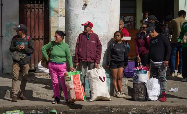 People wait to board transportation in Havana, Cuba, Friday, Feb. 6, 2026. (AP Photo/Ramon Espinosa)