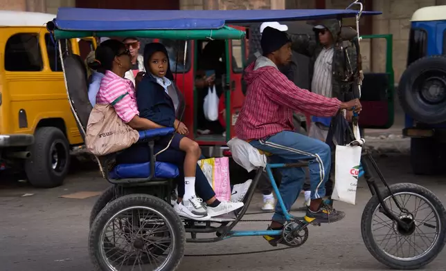 People use a bicycle taxi in Havana, Cuba, Friday, Feb. 6, 2026. (AP Photo/Ramon Espinosa)