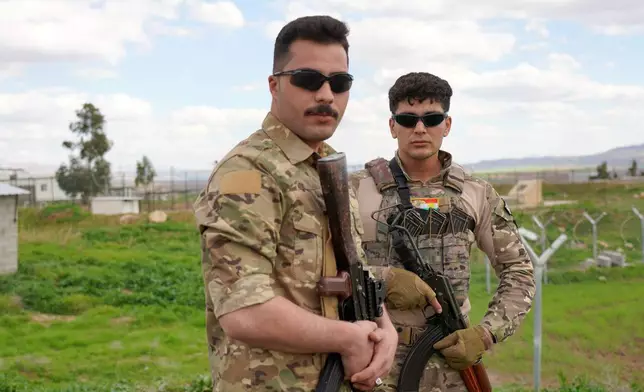Members of the Democratic Party of Iranian Kurdistan PDKI stand at a checkpoint leading to their base in the Koya district of Irbil, Iraq, Friday, Feb. 27, 2026. (AP Photo/Rashid Yahya)
