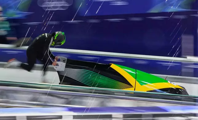 Jamaica's Mica Moore starts for a women's monobob training session at the 2026 Winter Olympics, in Cortina d'Ampezzo, Italy, Friday, Feb. 13, 2026. (AP Photo/Alessandra Tarantino)