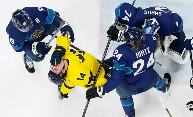 Finland's Roope Hintz, right, challenges Sweden's Joel Eriksson Ek during a preliminary round match of men's ice hockey between Finland and Sweden at the 2026 Winter Olympics, in Milan, Italy, Friday, Feb. 13, 2026. (AP Photo/Petr David Josek)
