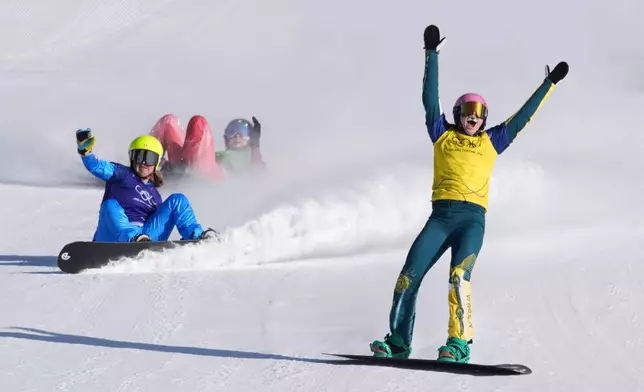 Australia's Josie Baff (17) celebrates her gold medal win past bronze medalist Italy's Michela Moioli (6) and Switzerland's Noemie Wiedmer (3) during the women's snowboard cross finals at the 2026 Winter Olympics, in Livigno, Italy, Friday, Feb. 13, 2026. (AP Photo/Lindsey Wasson)