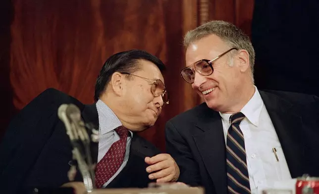 FILE - Sen. Daniel Inouye, D-Hawaii, left, and Rep. Lee Hamilton, D-Ind., chairmen of the Senate and House select committees on the Iran-Contra affair, confer as the group continued hearings on Capitol Hill, in Washington, May 8, 1987. (AP Photo/Lana Harris, File)