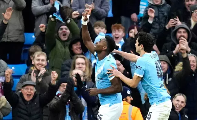 Manchester City's Marc Guehi, left, celebrates scoring during the English FA Cup fourth round soccer match between Manchester City and Salford City in Manchester, England, Saturday Feb. 14, 2026. (Nick Potts/PA via AP)