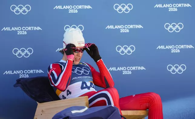 Johannes Hoesflot Klaebo, of Norway, sits on the leader's chair after crossing the finish line in the the cross country skiing men's 10km interval start free at the 2026 Winter Olympics, in Tesero, Italy, Friday, Feb. 13, 2026. (AP Photo/Evgeniy Maloletka)