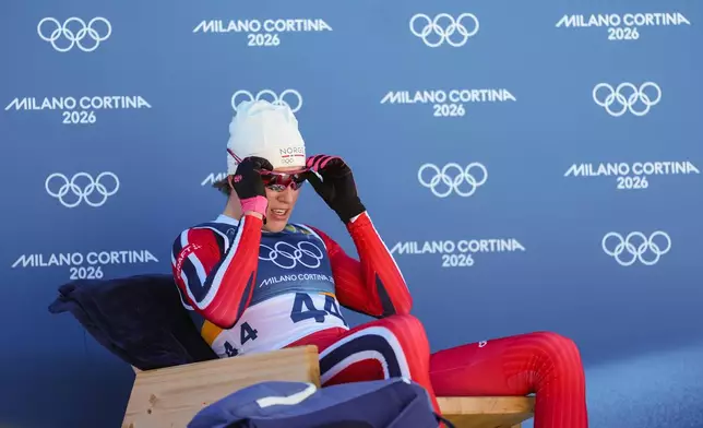 Johannes Hoesflot Klaebo, of Norway, sits on the leader's chair after crossing the finish line in the the cross country skiing men's 10km interval start free at the 2026 Winter Olympics, in Tesero, Italy, Friday, Feb. 13, 2026. (AP Photo/Evgeniy Maloletka)