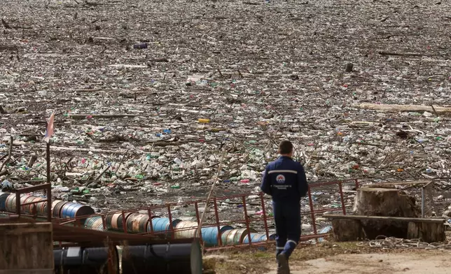 A worker toward the waste floating on the Drina river in Visegrad, Bosnia, Thursday, Feb. 5, 2026. (AP Photo/Armin Durgut)