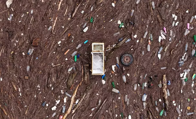 An aerial view shows a fridge and a car tire amongst other waste clogging the Drina river in Visegrad, Bosnia, Thursday, Feb. 5, 2026. (AP Photo/Armin Durgut)