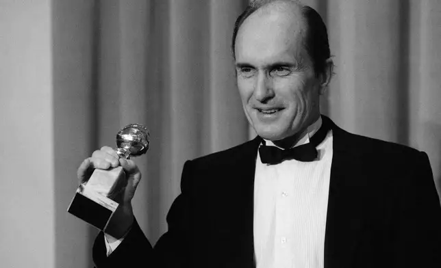 FILE - Actor Robert Duvall holds the Golden Globe award he won for best actor in a dramatic motion picture for his role in "Tender Mercies" in Beverly Hills, Calif., on Jan. 29,198 4. (AP Photo/Lennox Mclendon, File)