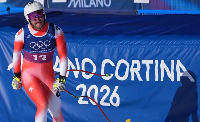 Switzerland's Alexis Monney celebrates at the finish area of an alpine ski men's downhill portion of a team combined race, at the 2026 Winter Olympics, in Bormio, Italy, Monday, Feb. 9, 2026. (AP Photo/Rebecca Blackwell)