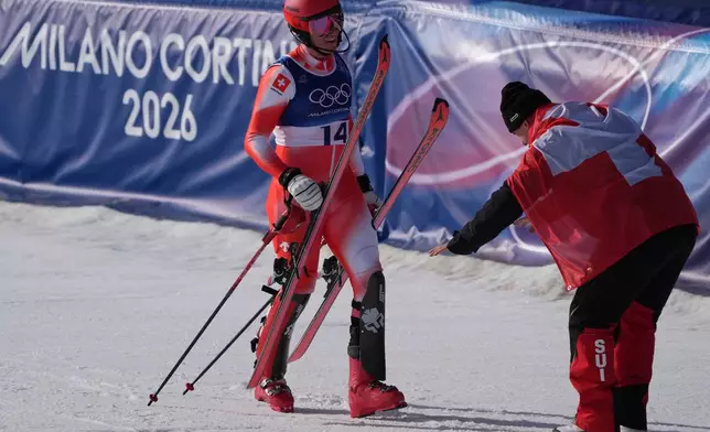 Switzerland's Franjo von Allmen, right, bows to his teammate Switzerland's Nef Tanguy at the finish area of an alpine ski men's slalom portion of a team combined race, at the 2026 Winter Olympics, in Bormio, Italy, Monday, Feb. 9, 2026. (AP Photo/Rebecca Blackwell)