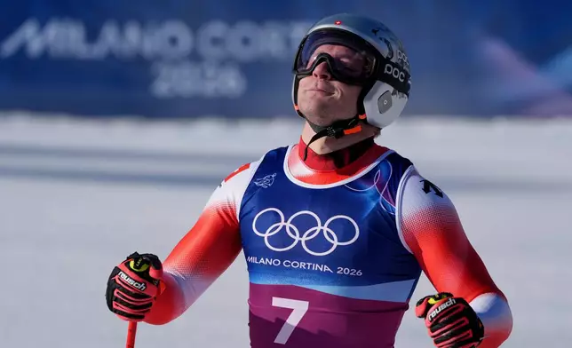Switzerland's Marco Odermatt celebrates at the finish area of an alpine ski men's downhill portion of a team combined race, at the 2026 Winter Olympics, in Bormio, Italy, Monday, Feb. 9, 2026. (AP Photo/Rebecca Blackwell)