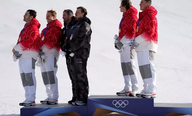 From right, gold medalists Switzerland's Franjo von Allmen, and teammate Tanguy Nef, joint-silver medalists Austria's Manuel Feller and teammate Vincent Kriechmayr, and Switzerland's Marco Odermatt, and teammate Loic Meillard, listen to the Swiss national anthem at the finish area of an alpine ski men's team combined race, at the 2026 Winter Olympics, in Bormio, Italy, Monday, Feb. 9, 2026. (AP Photo/Julia Demaree Nikhinson)
