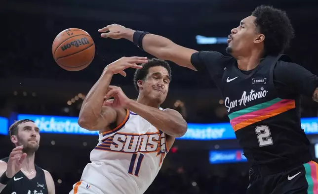 San Antonio Spurs guard Dylan Harper (2) knocks the ball away from Phoenix Suns forward Oso Ighodaro (11) during the first half of an NBA basketball game in Austin, Texas, Thursday, Feb. 19, 2026. (AP Photo/Eric Gay)