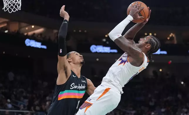 Phoenix Suns guard Jalen Green, right, shoots against San Antonio Spurs forward Victor Wembanyama (1) during the first half of an NBA basketball game in Austin, Texas, Thursday, Feb. 19, 2026. (AP Photo/Eric Gay)