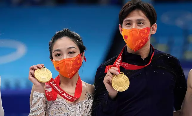 FILE - Gold medalists, Sui Wenjing and Han Cong, of China, pose during a medal ceremony after the pairs free skate program during the figure skating competition at the 2022 Winter Olympics, Feb. 19, 2022, in Beijing. (AP Photo/David J. Phillip, file)