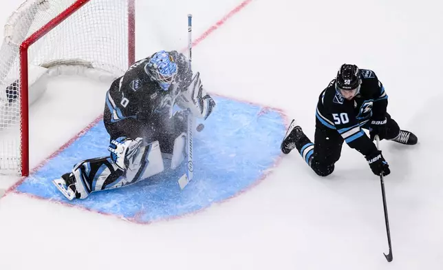 Utah Mammoth goaltender Karel Vejmelka, left, blocks the puck with defensive help from defenseman Sean Durzi (50) during the first period of an NHL hockey game against the Minnesota Wild, Friday, Feb. 27, 2026, in Salt Lake City. (AP Photo/Tyler Tate)