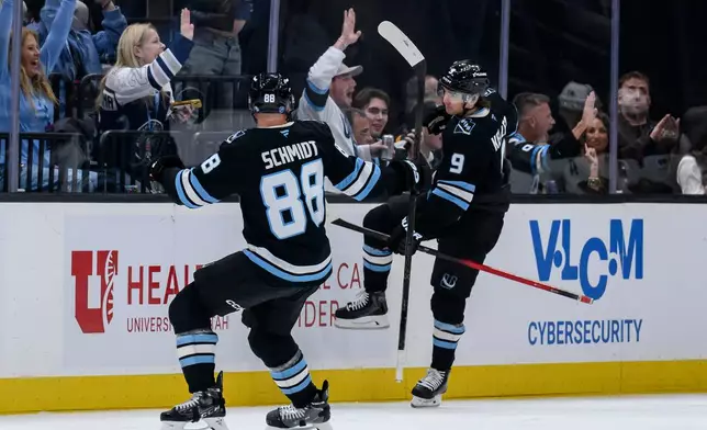 Utah Mammoth right wing Clayton Keller (9) and defenseman Nate Schmidt (88) celebrate after Keller's goal during the second period of an NHL hockey game against the Minnesota Wild, Friday, Feb. 27, 2026, in Salt Lake City. (AP Photo/Tyler Tate)