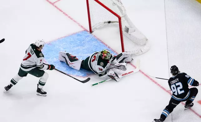 Utah Mammoth center Logan Cooley (92) scores a a short-handed goal against Minnesota Wild goaltender Jesper Wallstedt, center, during the first period of an NHL hockey game, Friday, Feb. 27, 2026, in Salt Lake City. (AP Photo/Tyler Tate)
