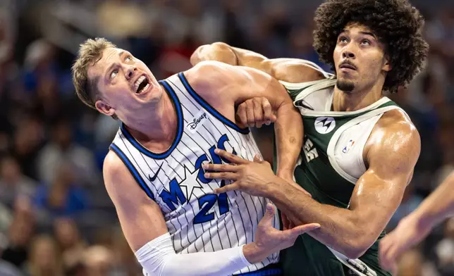 Orlando Magic forward/center Moritz Wagner, left, and Milwaukee Bucks center Jericho Sims fight for position on a rebound during the first half of an NBA basketball game, Wednesday, Feb. 11, 2026, in Orlando, Fla. (AP Photo/Willie J. Allen Jr.)