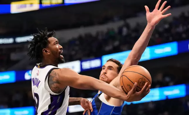 Sacramento Kings guard Malik Monk shoots at Dallas Mavericks' Dwight Powell, right, defends in the first half of an NBA basketball game in Dallas, Thursday, Feb. 26, 2026. (AP Photo/Tony Gutierrez)