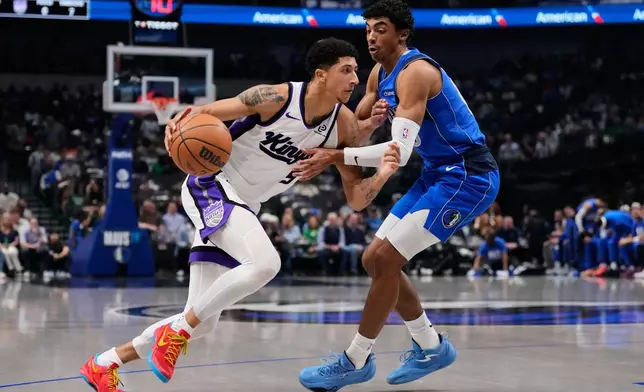 Sacramento Kings' Nique Clifford drives to the basket as Dallas Mavericks' Max Christie, right, defends in the first half of an NBA basketball game in Dallas, Thursday, Feb. 26, 2026. (AP Photo/Tony Gutierrez)
