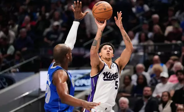 Sacramento Kings guard Nique Clifford (5) shoots over Dallas Mavericks forward Khris Middleton, left, in the first half of an NBA basketball game in Dallas, Thursday, Feb. 26, 2026. (AP Photo/Tony Gutierrez)