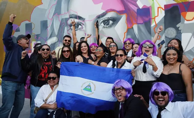 Fans of Colombian pop star Shakira pose for a photo with a Nicaraguan flag before her concert at the National Stadium in San Salvador, El Salvador, Thursday, Feb. 12, 2026. (AP Photo/Salvador Melendez)