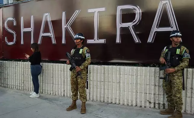 Soldiers stand in front of a sign for Colombian pop star Shakira before her concert at the National Stadium in San Salvador, El Salvador, Thursday, Feb. 12, 2026. (AP Photo/Salvador Melendez)